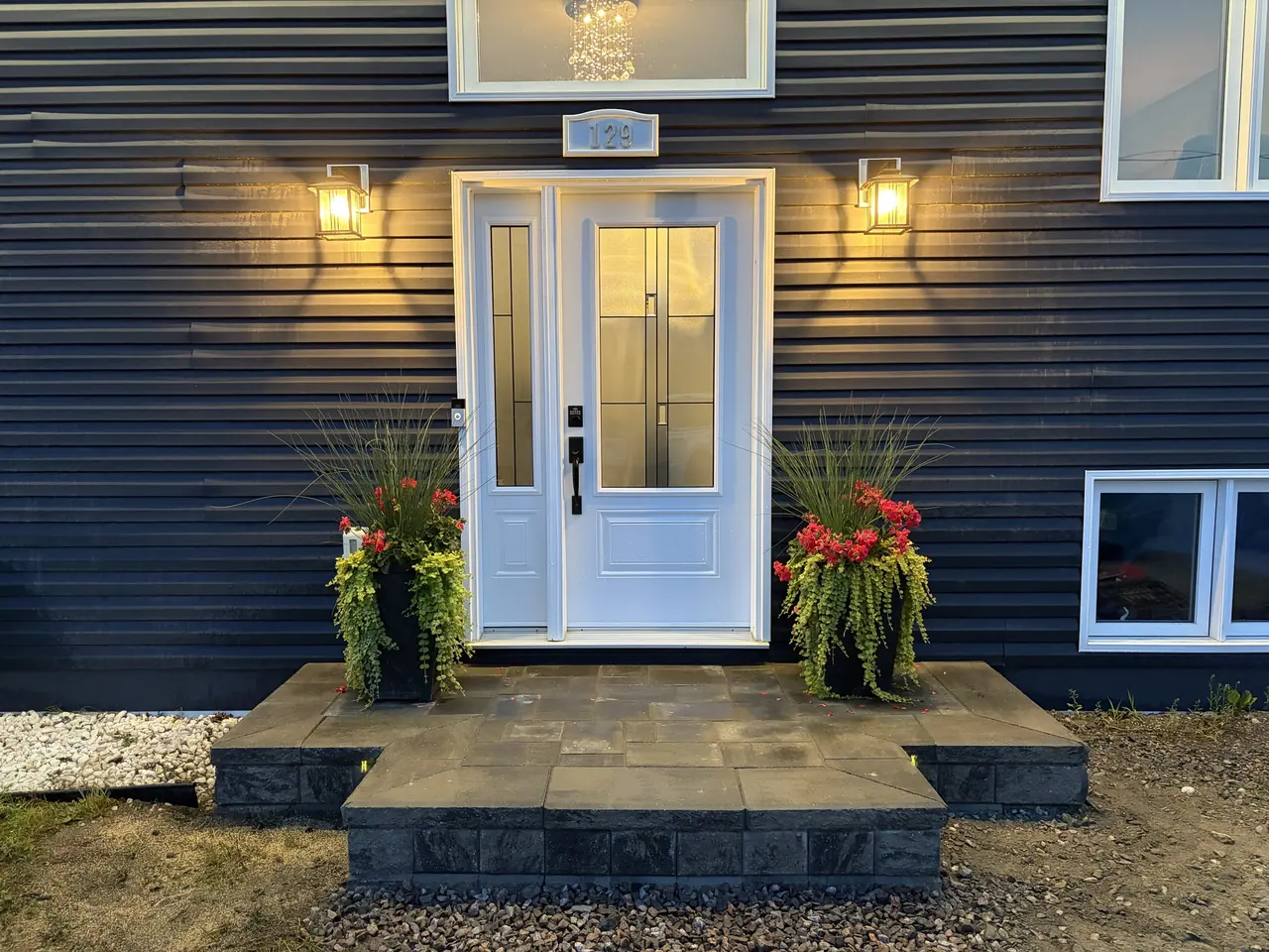 Custom front entrance with stone steps and lantern lighting built by Edwards Landscape and Construction in North Bay