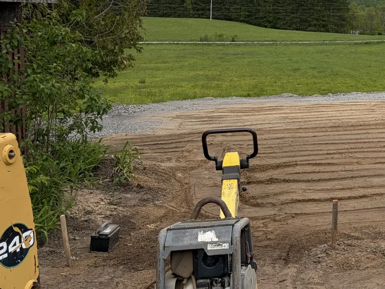 Plate compactor compacting a graded base by Edwards Landscape and Construction near North Bay