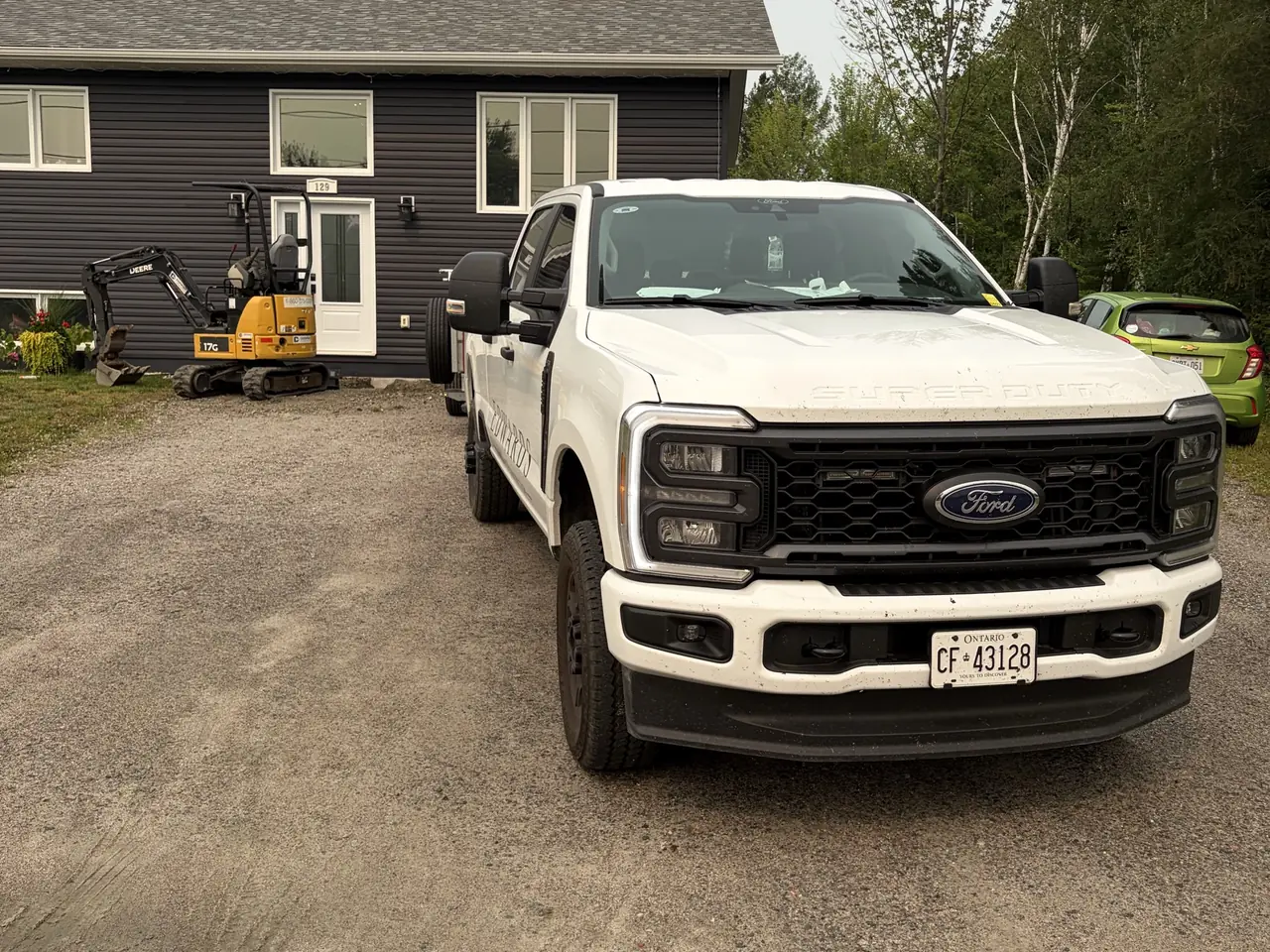 Mini excavator and Edwards Landscape and Construction truck on a job site near North Bay