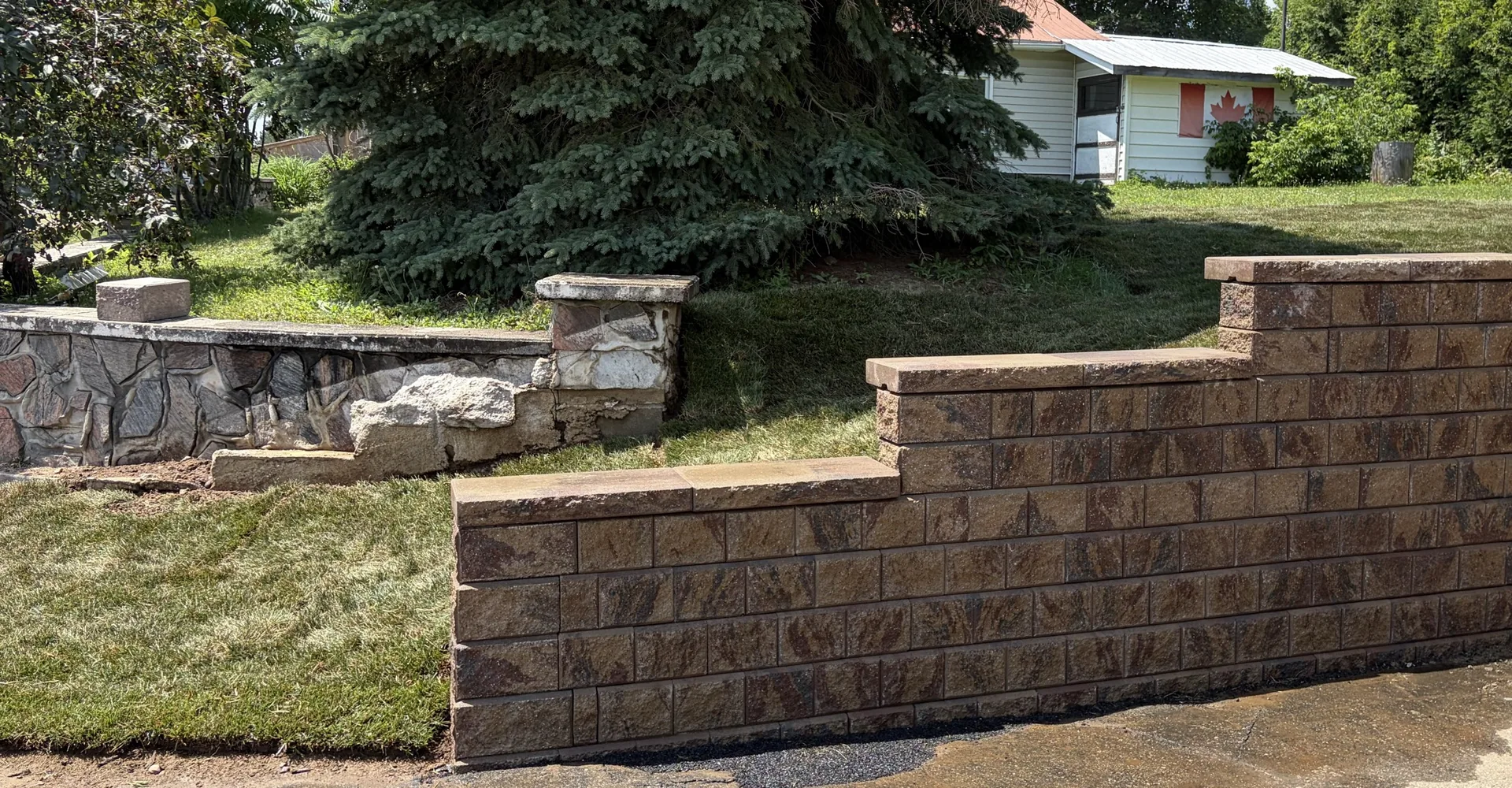 Engineered block retaining wall with stone accents built by Edwards Landscape and Construction in North Bay, Ontario