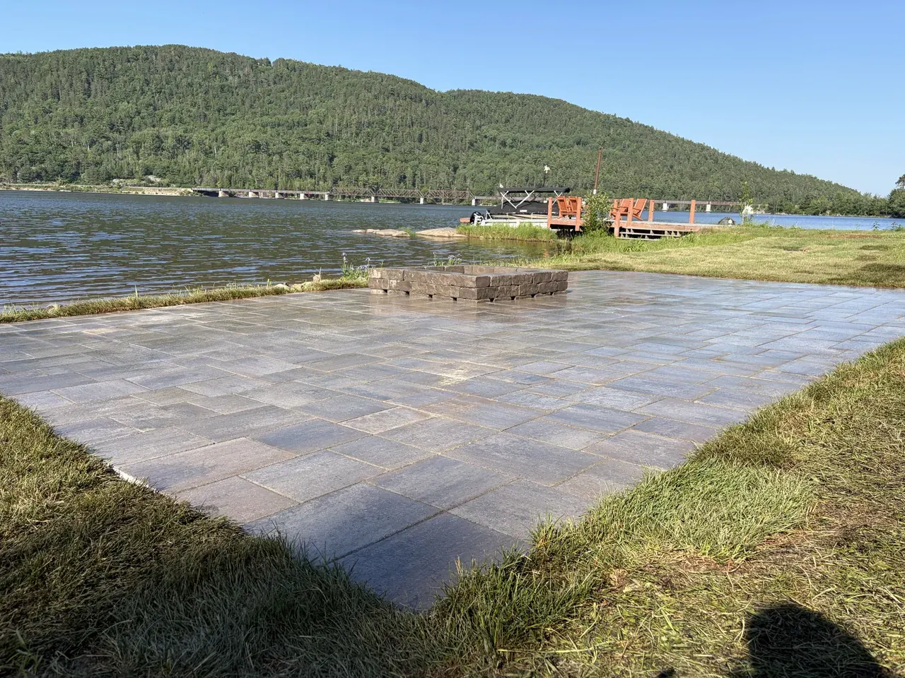 Edwards Landscape and Construction lakeside paver patio with a stone fire pit on a Northern Ontario shoreline