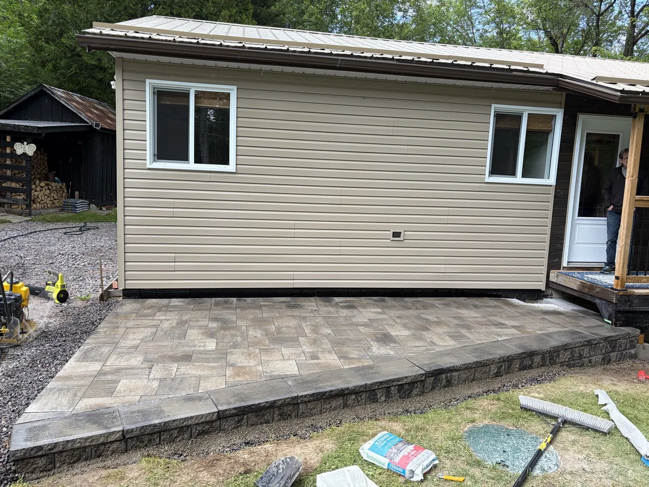 Raised interlock paver patio and steps against a home in North Bay