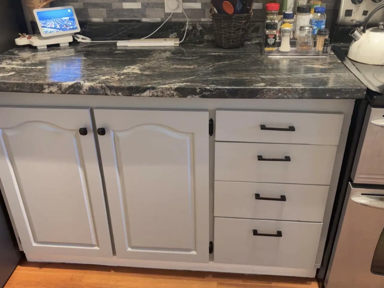 Refinished white kitchen cabinets and granite counter by Edwards Landscape and Construction in North Bay