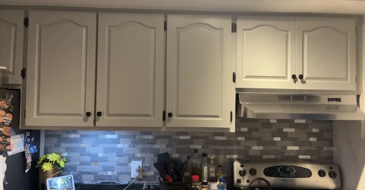 Refinished white kitchen cabinets and tile backsplash renovated by Edwards Landscape and Construction in North Bay, Ontario