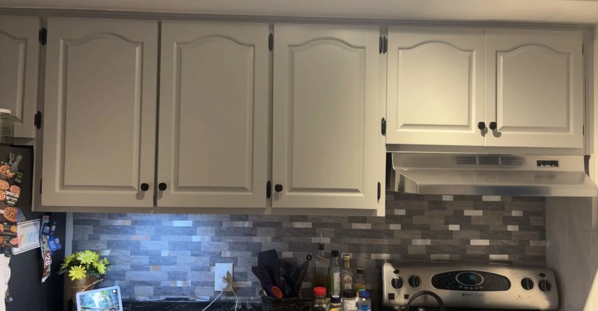 Refinished white kitchen cabinets and tile backsplash renovated by Edwards Landscape and Construction in North Bay, Ontario