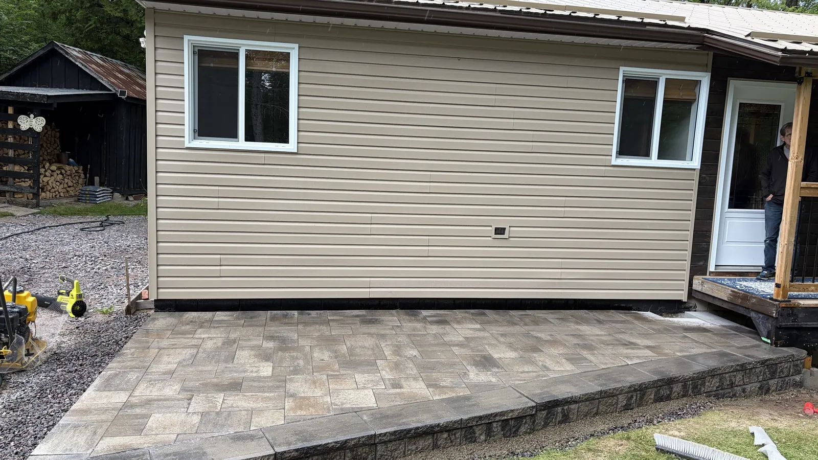 Raised paver patio and steps built against a home by Edwards Landscape and Construction